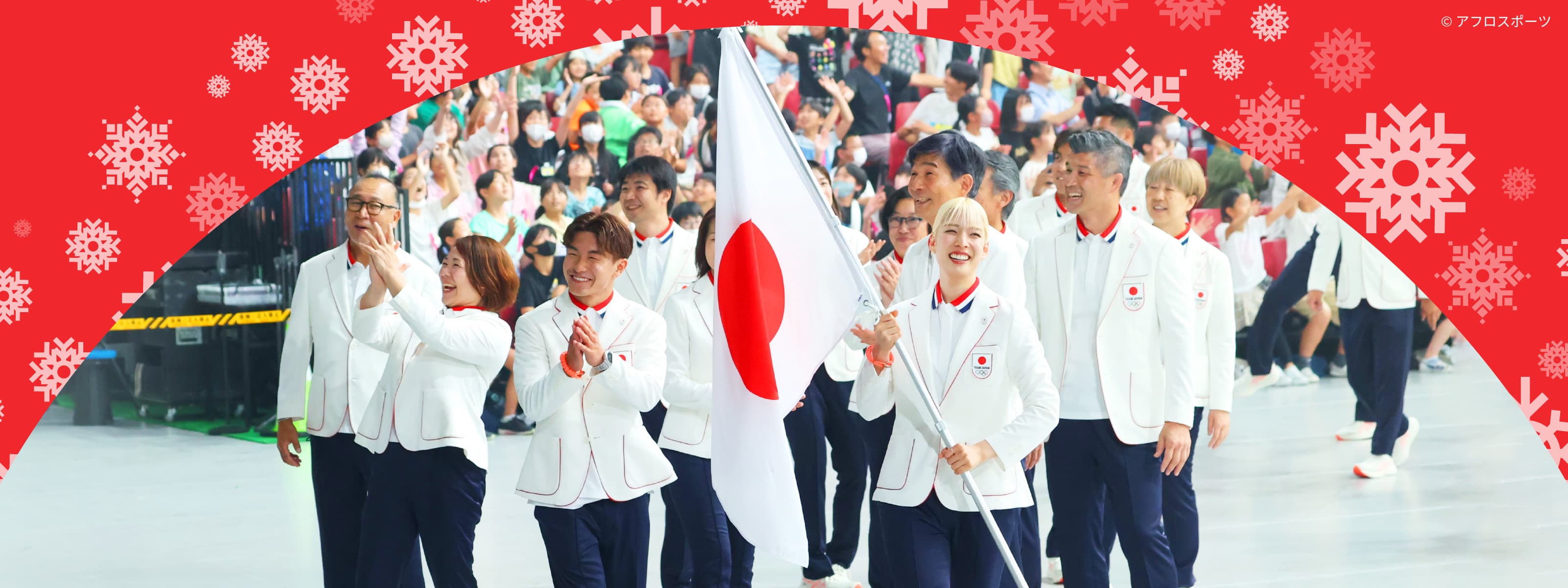 写真：日本選手団が国旗を持って入場しているシーン